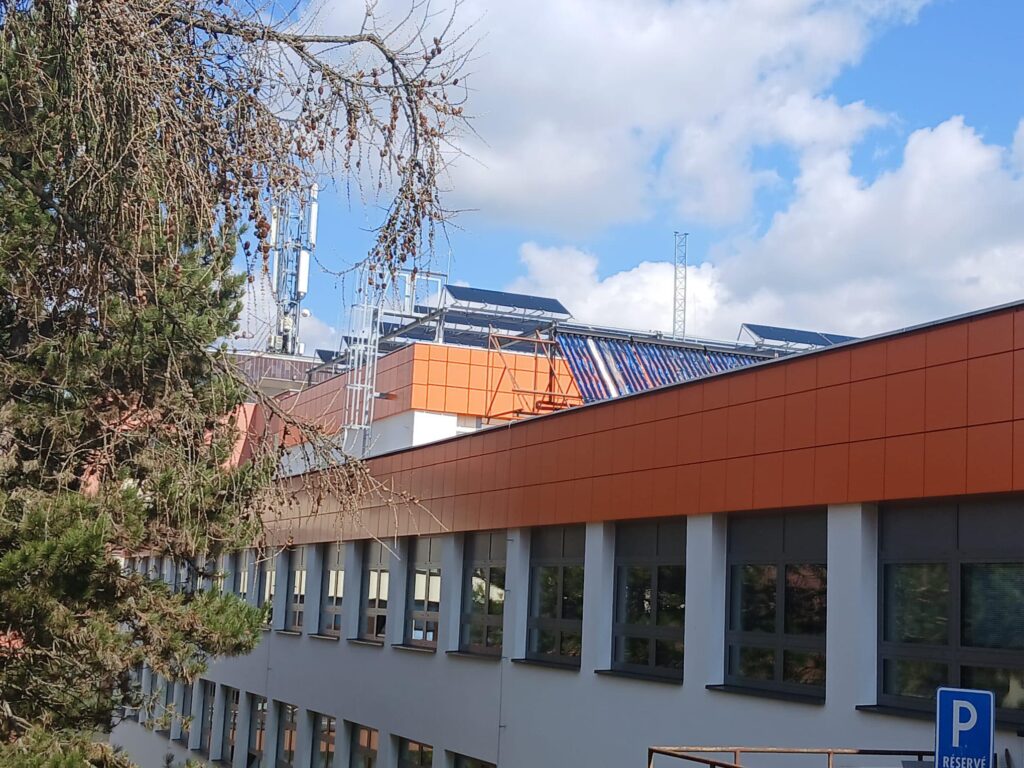 Budynek z panelami słonecznymi na dachu, anteną telekomunikacyjną i znakiem "P RÉSERVÉ".