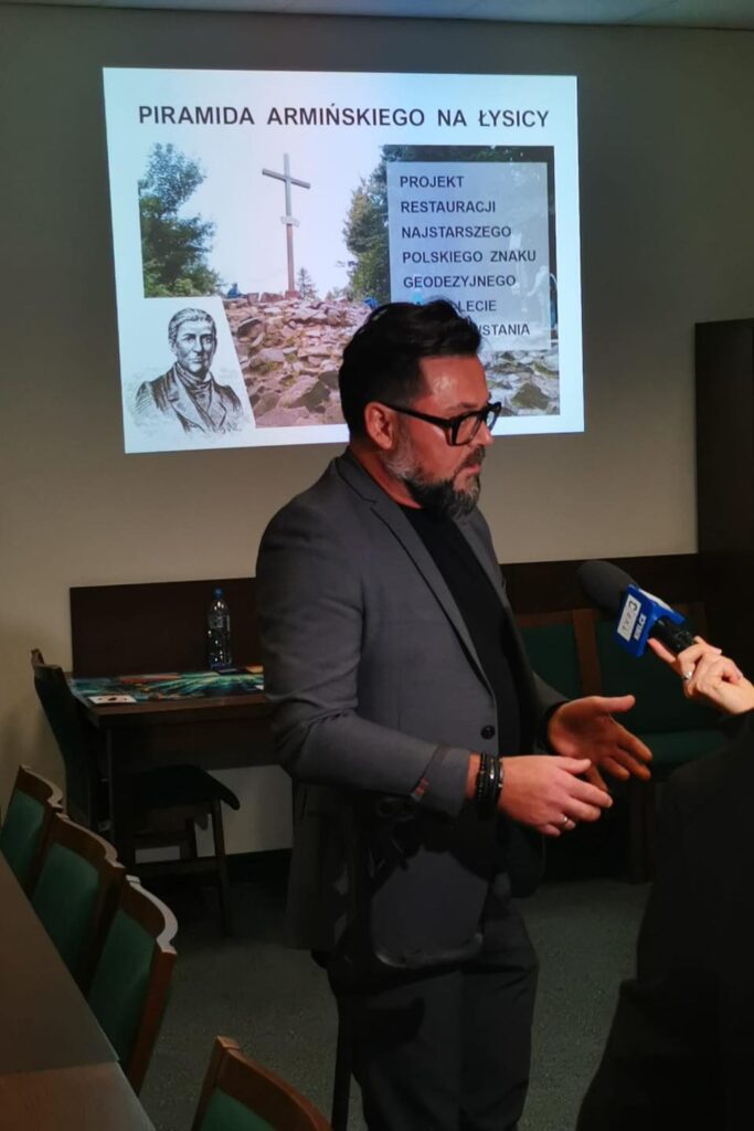 Prezentacja o "Piramidzie Armińskiego na Łysicy", z mężczyzną udzielającym wywiadu.