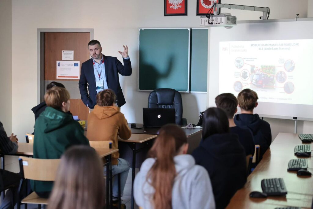 Mężczyzna prowadzi prezentację o skanowaniu laserowym MLS. W sali są uczniowie i tablica.