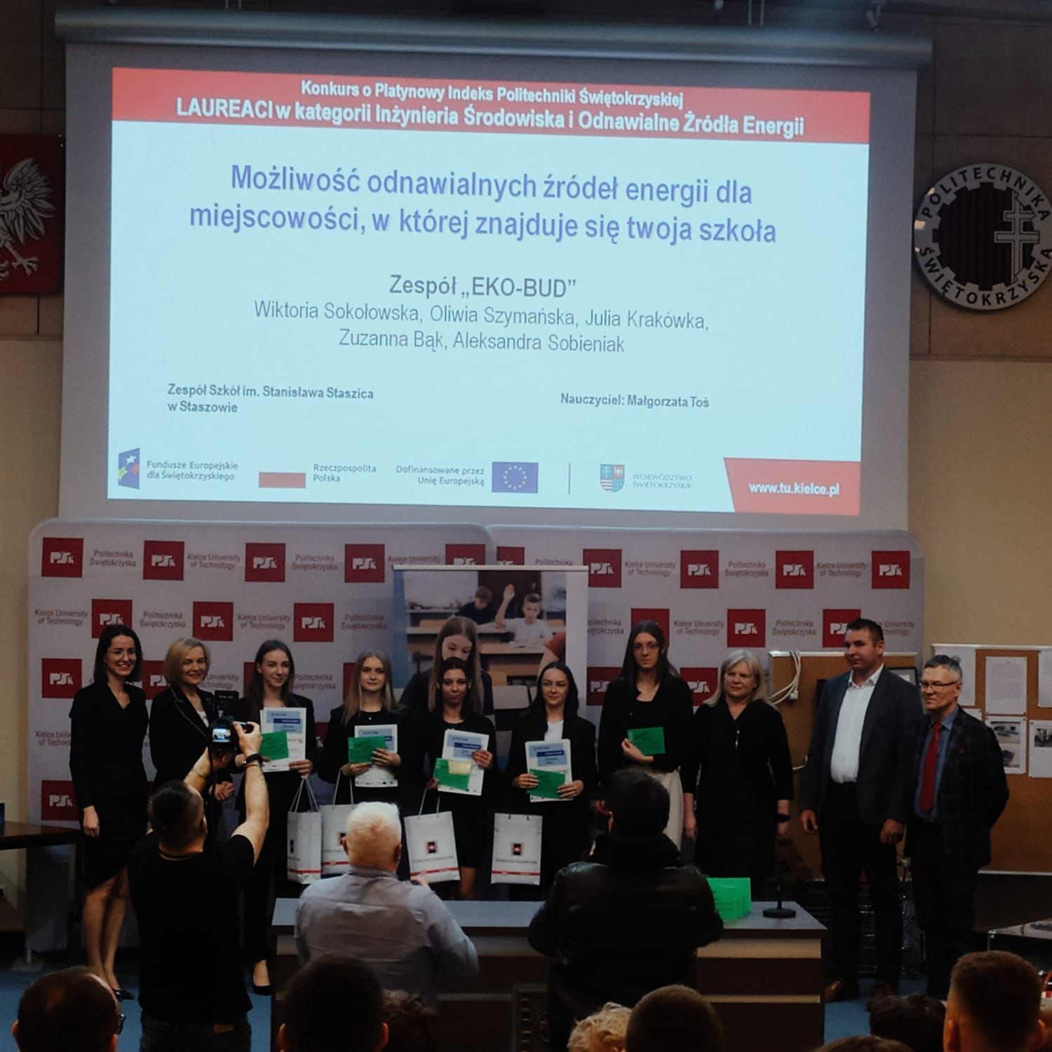 Grupa osób odbiera nagrody na scenie. Na ekranie tytuł konkursu "Możliwość odnawialnych źródeł energii".