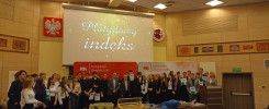 Grupa studentów i wykładowców na scenie. Na ekranie napis "Platynowy indeks".