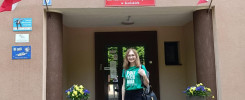 Kobieta przed budynkiem II Liceum Ogólnokształcącego z Oddziałami Dwujęzycznymi im. Marii Skłodowskiej-Curie w Końskich.