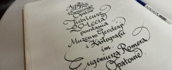 Zapisana kaligraficznie kartka z tekstem o jubileuszu Muzeum Geodezji i Kartografii im. Eugeniusza Romera w Opatowie.