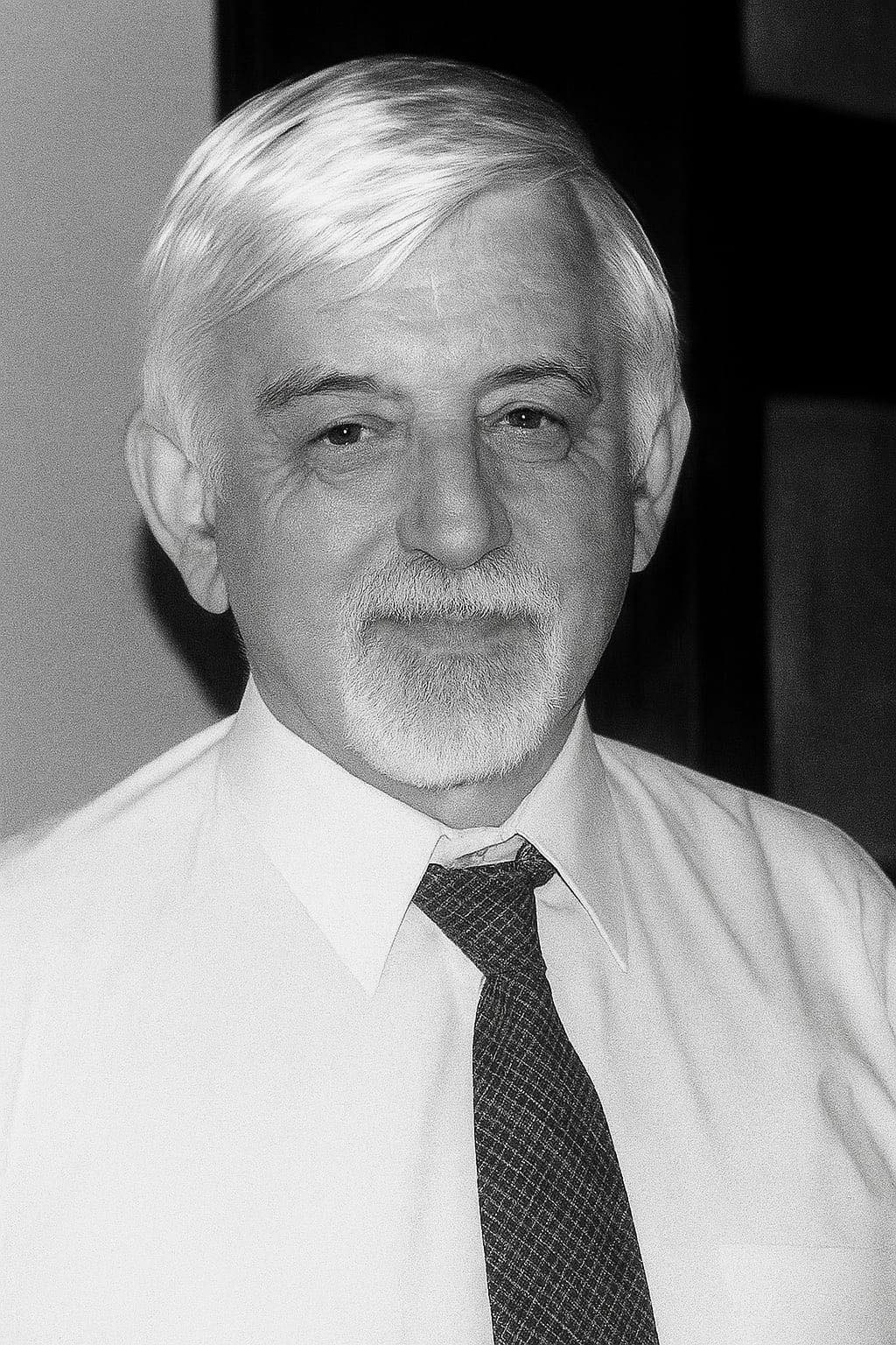 Portret mężczyzny w białej koszuli i krawacie. Siwe włosy, broda.